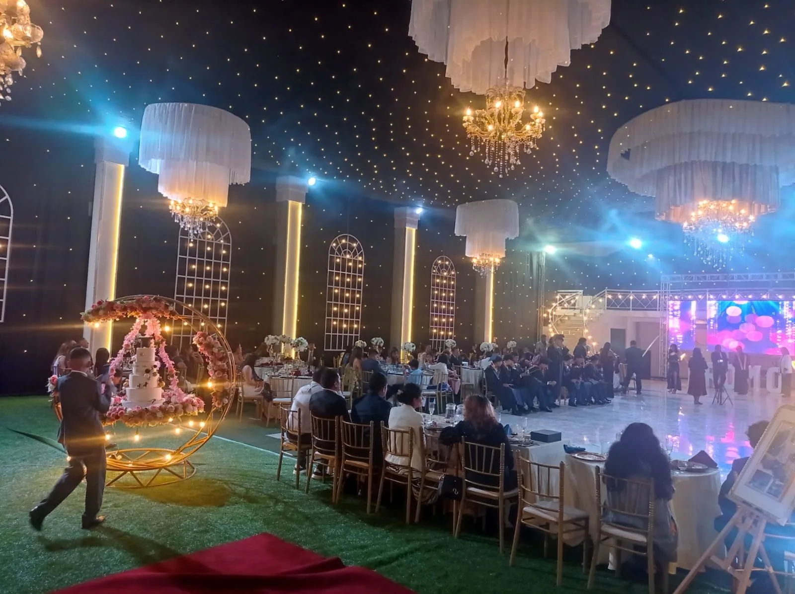 Salón de noche con candelabros y pastel de celebración