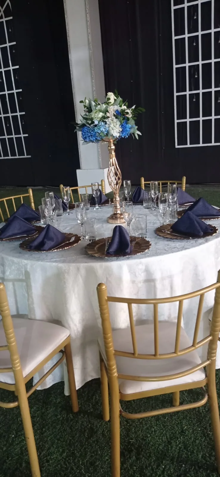 Mesa montada con centro floral azul y cristalería
