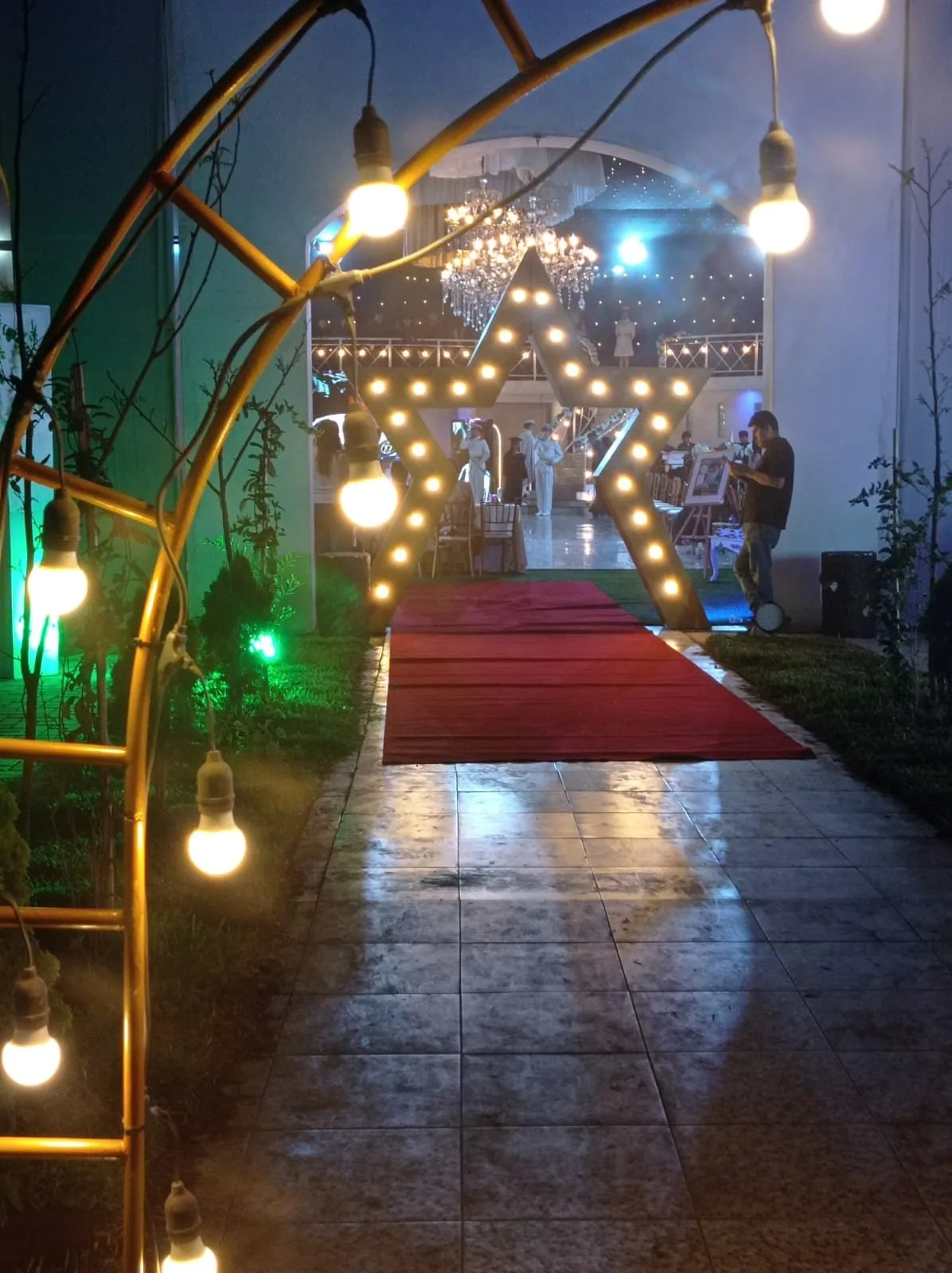 Patio al aire libre con arcos de bombillas y estrella luminosa